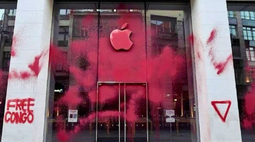 Apple store facade covered in red paint. Graffiti onn the left reads FREE CONGO, with a downward triangle on the right.