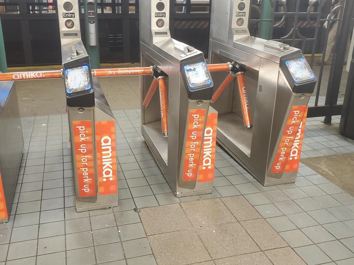 Three turnstiles with smashed OMNY readers.